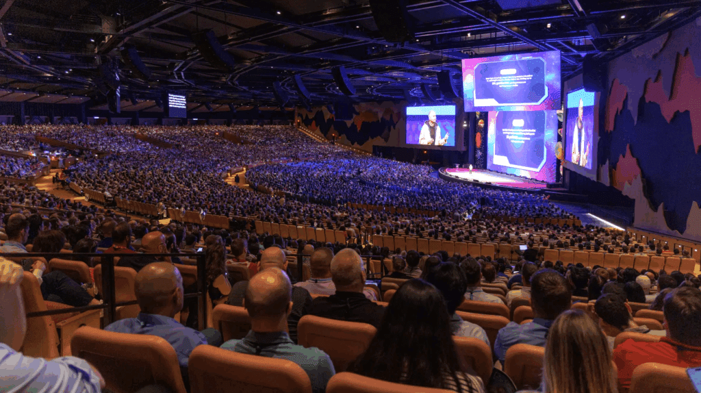 view from the back of the auditorium, showing a huge crowd and the stage