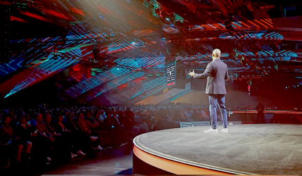 image of stage at summit showing speaker and large crowd